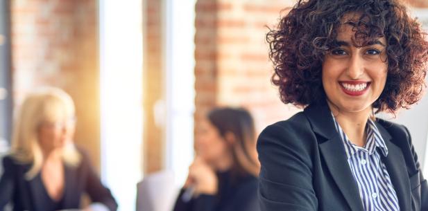 Jonge vrouw op kantoor met collega's 